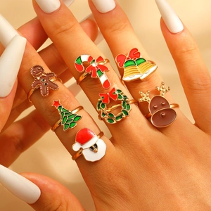 Close-up of model wearing seven colorful Christmas rings with deer and tree motifs