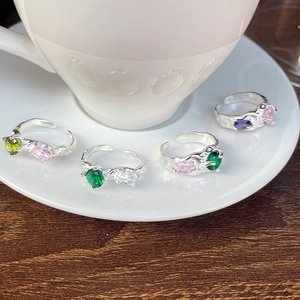 Detailed view of silver open rings with lava texture and colorful inlaid gemstones
