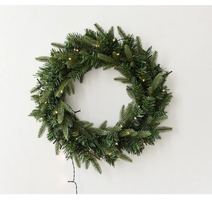 Detail of pre-lit Christmas wreath featuring lush PE needles and warm white LED lights