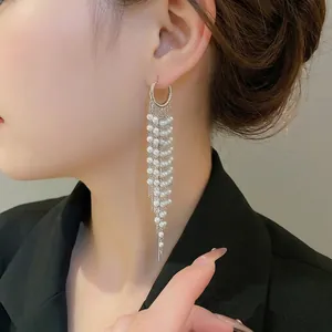 Elegant 18k gold plated pearl tassel earrings on model with long cascading chains