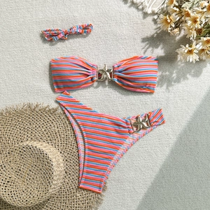 Detailed flat lay of striped bikini set with gold starfish charms and matching headband