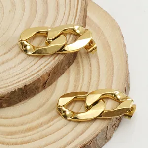 Polished 18K gold plated titanium steel interlocking link earrings on wood background