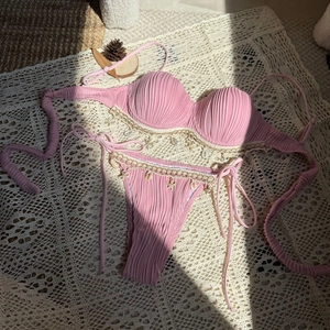 Pink ribbed bikini detail with crochet lace trim and decorative seashell starfish charms