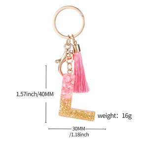 Pink resin letter L keychain with gold glitter, pink tassel, and dimension markings