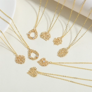 Detail showing assorted 14K gold-plated branch and heart pendants with tiny zircon stones