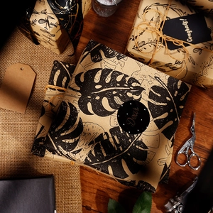 Brown kraft paper gift wrap set with monstera leaf patterns, twine, and matching cards