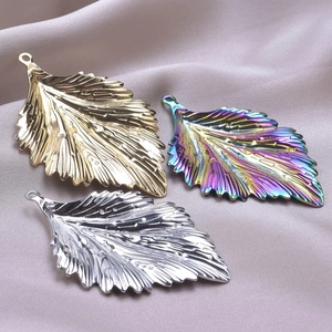 Detailed view of leaf-shaped metal charms in gold, silver and rainbow colors for DIY jewelry