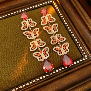 Détail de boucles d'oreilles papillon vintage avec pompons en zircon rouge sur velours
