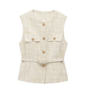 Detailed texture of beige tweed vest with gold buttons and matching waist belt