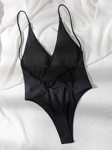 Back view of a black one-piece swimsuit featuring a sexy backless cross-tie design