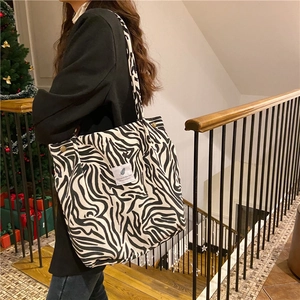 Detailed view of zebra print corduroy tote bag with decorative You need this one label