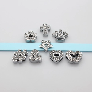 Selection of silver rhinestone-studded alloy charms including crown and heart on a blue ribbon