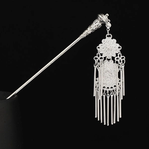 Detailed close-up of Miao silver hair stick featuring hollow carving and elegant tassels