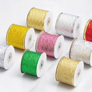 Sparkling Christmas glitter ribbons in multiple colors on white spools for festive gift wrapping