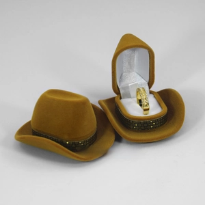 Brown cowboy hat jewelry box with velvet texture showing a gold ring inside