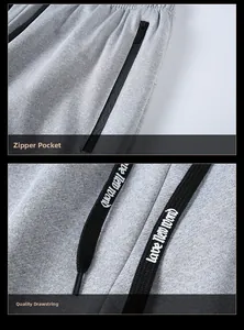 Detalle de pantalón deportivo gris con bolsillo de cremallera y cordón con letras blancas