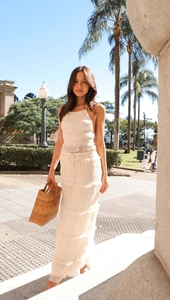 Detail of white sleeveless halter neck top and pleated maxi skirt in a resort style