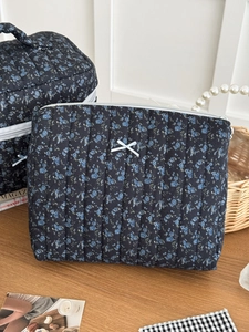 Macro shot of quilted floral cosmetic bags with blue patterns and white bow details