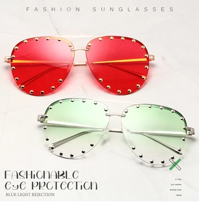 Detail of red and green aviator sunglasses with gold metal frames and stud accents