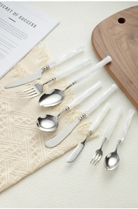 Flat lay of 304 stainless steel cutlery set with white bamboo style acrylic handles
