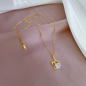 Close-up of golden swan pendant necklace with sparkling zircon on silk background
