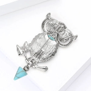 Detailed back view of silver alloy owl brooch featuring turquoise stone inlay and pendant