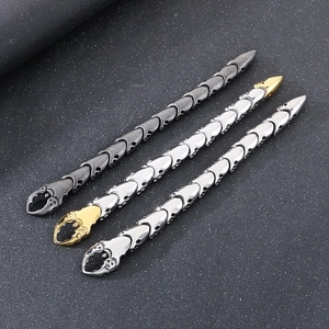 Vue macro de bracelets punk en acier inoxydable en or, argent et gris fusil sur fond gris