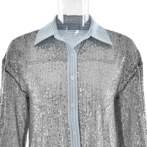 Detail of silver sequined shirt with light blue striped collar and professional white buttons