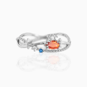 Detail of silver crab ring with orange gemstone and sea star zircon accents on white