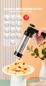 Macro shot of stainless steel cookie press gun with thirteen different pattern discs