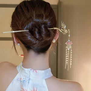 Détail d'un pic à cheveux phénix et lotus avec perles porté sur un chignon élégant