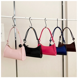 Row of colorful glossy baguette bags in pink, black, blue and red on display