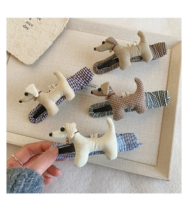 Détail de pinces à cheveux en forme de chien en tissu à carreaux kaki, bleu et marron