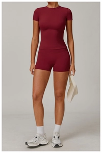 Detail of dark red moisture-wicking yoga top and high-waist sports shorts with crew neck