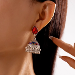 Vintage silver Jhumka earrings with red teardrop stones and colorful rhinestones on a model
