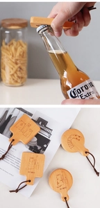 Detail of wooden beer bottle opener with cartoon animal engraving and leather lanyard