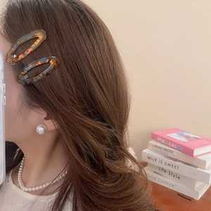 Elegant woman wearing tortoiseshell acetate hair clip and pearl jewelry set accessories