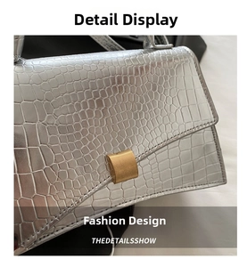 Detailed close-up of silver crocodile embossed faux leather and a golden square metal buckle