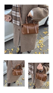 Detailed view of the brown pleated leather texture and gold hardware on a boston bag
