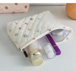 Détail d'une grande trousse à maquillage matelassée blanche à motifs de dessins animés