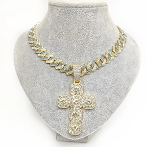 Detail of gold Cuban chain necklace with a blue and white diamond-encrusted cross pendant