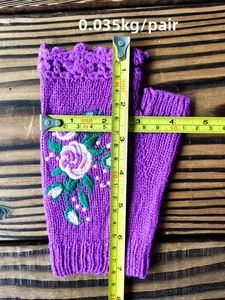 Close-up of purple knit fingerless glove with rose embroidery and tape measure