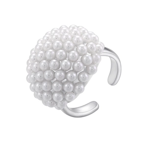 Macro shot of elegant round white imitation pearls set on an adjustable silver metal ring