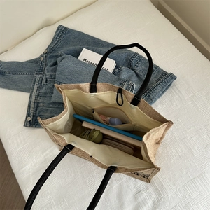 Ethnic linen tote bag with black strap handles and organized interior storage space