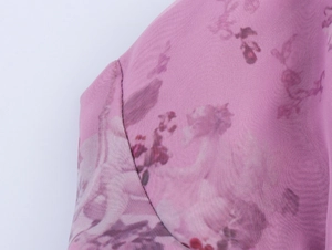 Close-up of pink floral organza fabric texture and fine stitching detail on dress