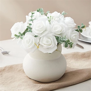 Artificial white roses with eucalyptus in a white ceramic vase for home decoration