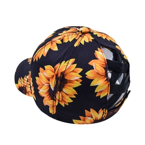 Black ponytail baseball cap with yellow sunflower print and elastic cross-back design