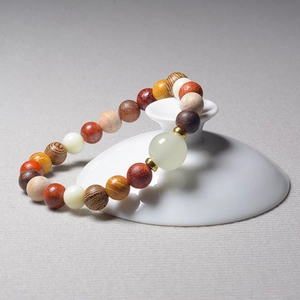 Detailed shot of multi-color beaded bracelet with lion carving and bamboo style wood textures