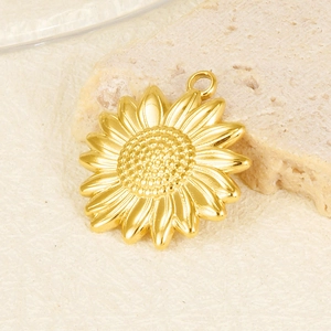 Macro shot of 304 stainless steel gold sunflower pendant for DIY necklace on stone