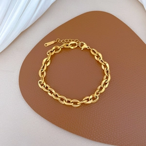 Détail du bracelet chaîne à maillons dorés avec fermoir mousqueton réglable sur support